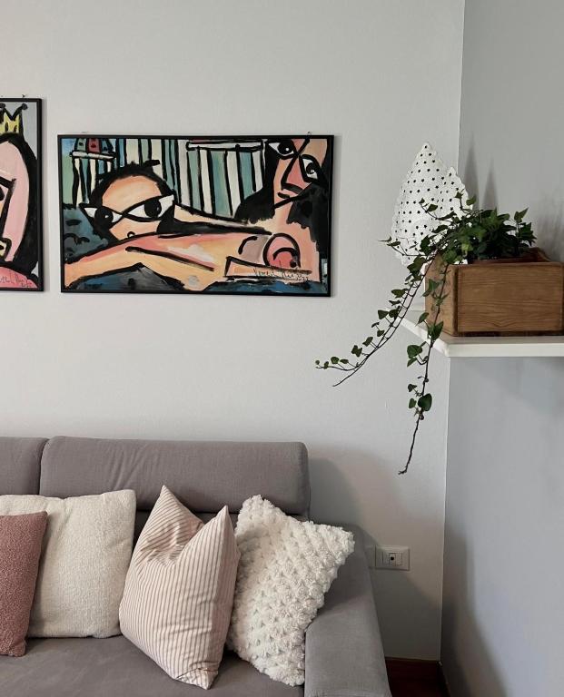 a living room with a couch and some pictures on the wall at Casa Altea in Pordenone