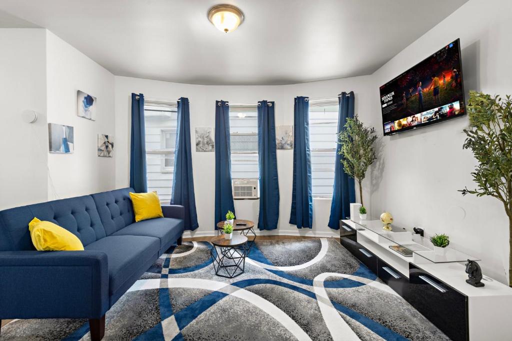 a blue couch in a living room with blue curtains at Fun Family getaway - NYC & NWK w free parking in Newark