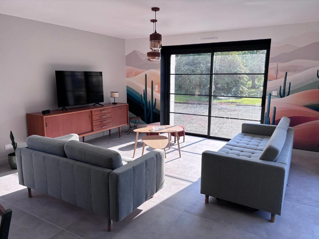 un salon avec deux canapés et une télévision dans l'établissement Gîte La Marnière, à Luzillé