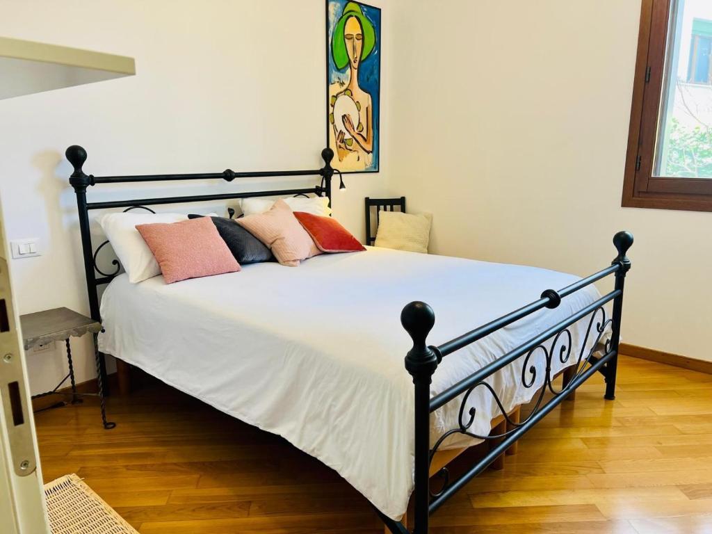 a bedroom with a bed with white sheets and pink pillows at Casa Altea in Pordenone