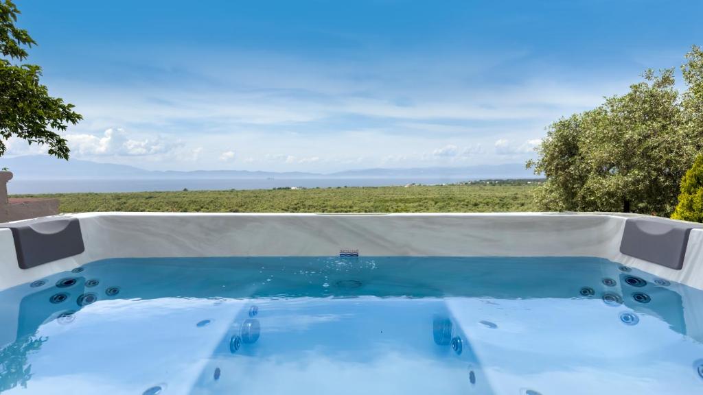 a hot tub with a view of a field at Villa Mitsekou in Prinos