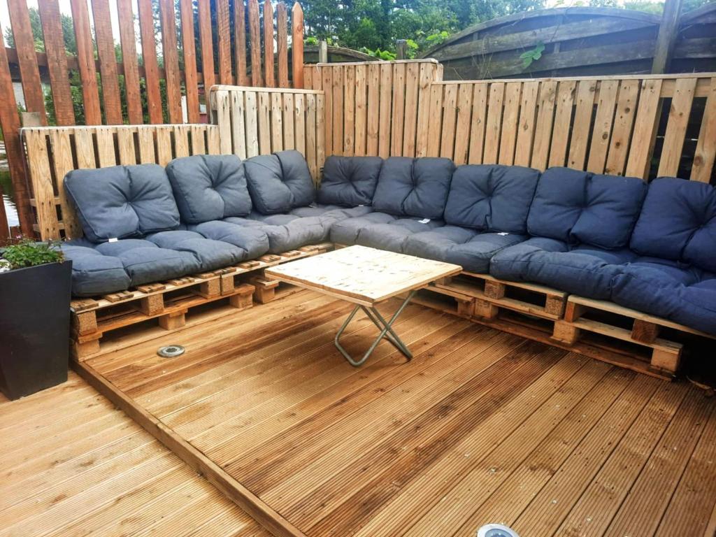a blue couch on a deck with a coffee table at La détente in Féchain