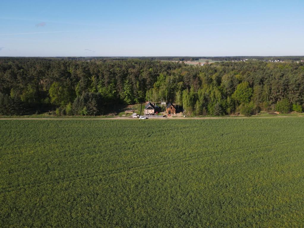 an aerial view of a large green field with a house at LESNA 41a - Nowoczesna Stodoła w stylu skandynawskim in Dobrcz
