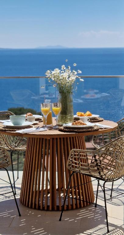 a table with food and drinks and a vase of flowers at Perla Hvar ApartHotel in Ivan Dolac