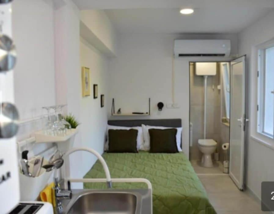 a bedroom with a green bed and a sink at Studio Bire in Lumbarda