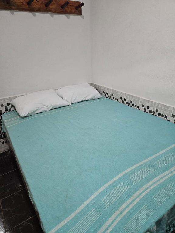 a large bed in a room with a blue mattress at Quarto - suíte pequi - Centro Histórico da Cidade de Goiás in Goiás