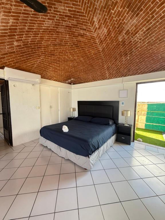 ein Schlafzimmer mit einem großen Bett in einer Ziegelwand in der Unterkunft Hermoso loft frente al mar vista increíble in Cancún