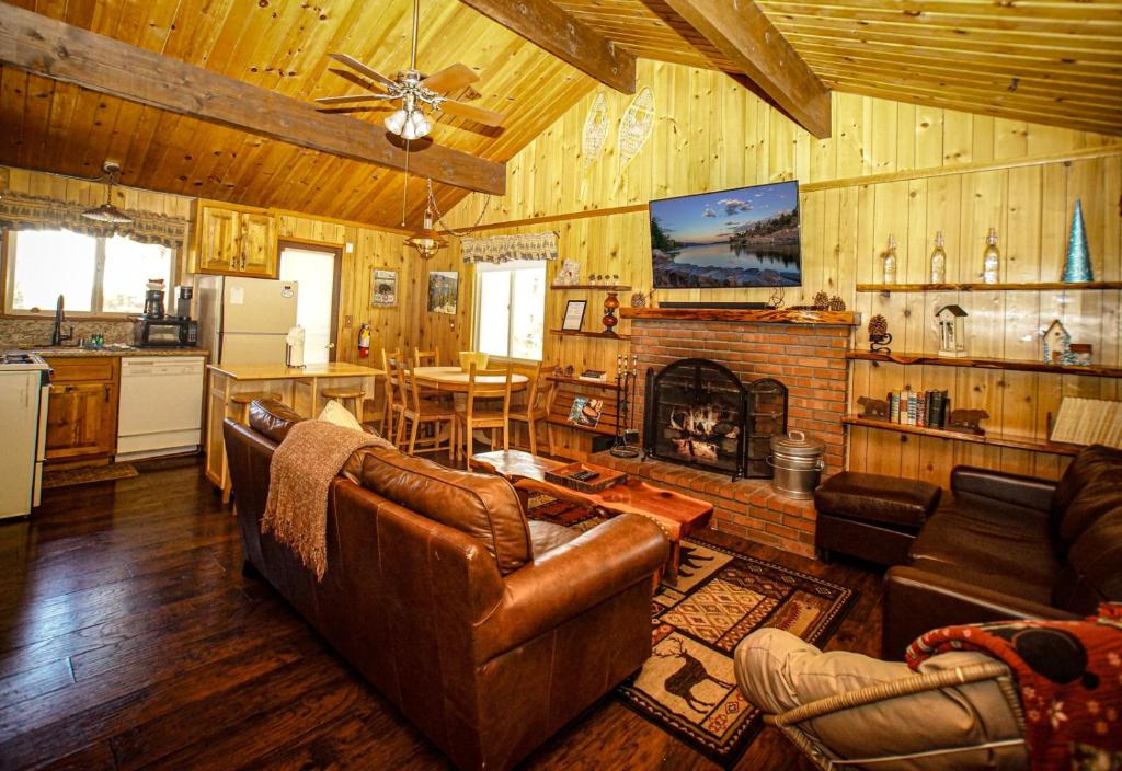 a living room with a couch and a fireplace at Big Wood Pines - Relaxing home with a large fenced yard for your furry friends to enjoy! in Big Bear City