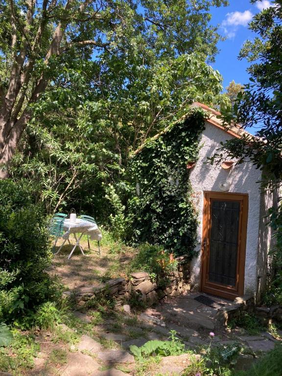 une petite maison avec une porte en bois et un banc dans l'établissement Nuit entre mer et montagne, à Caixas