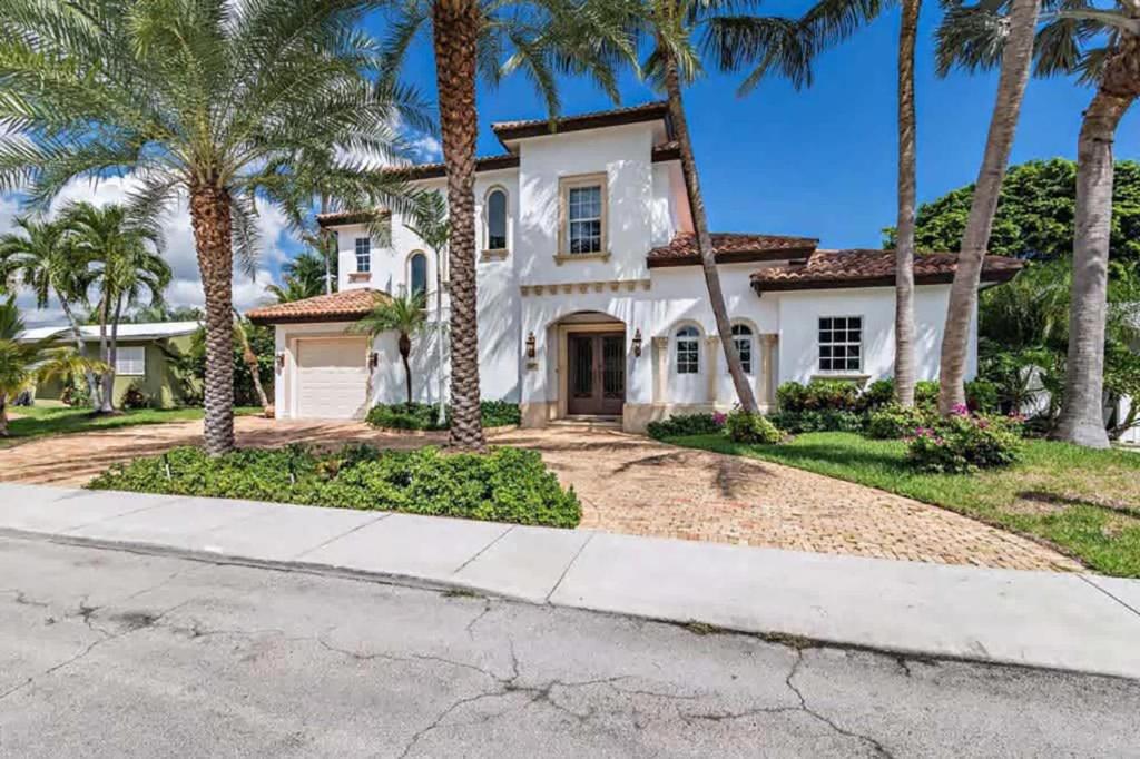 a house with palm trees in front of a street at Gregory Place - Dine Alfresco by the Pool in South End Sophistication in West Palm Beach
