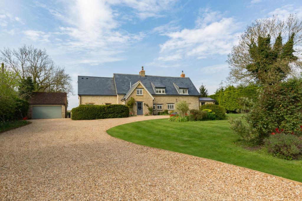 a large house with a gravel driveway at Church End Cottage in Milton Keynes