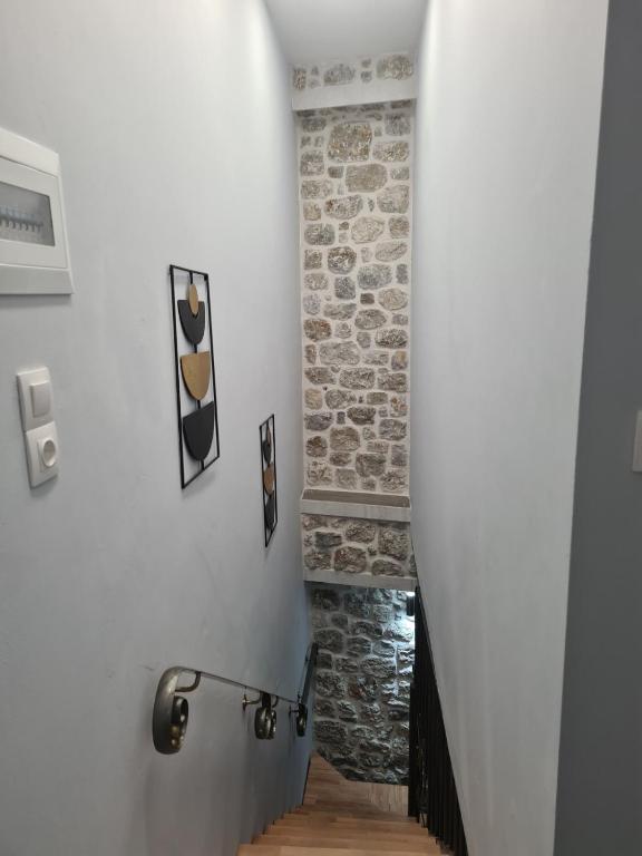 a hallway with a staircase with a stone wall at Amyrissa House in Mesochórion