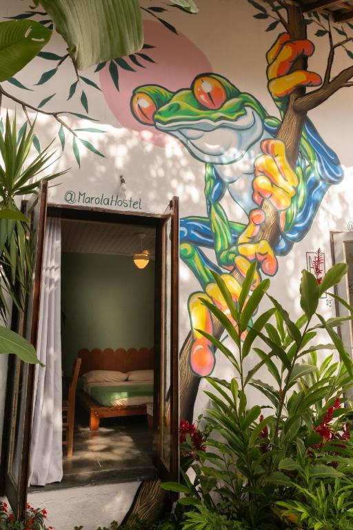 a room with a painting of a frog on the wall at Marola Hostel in Ubatuba