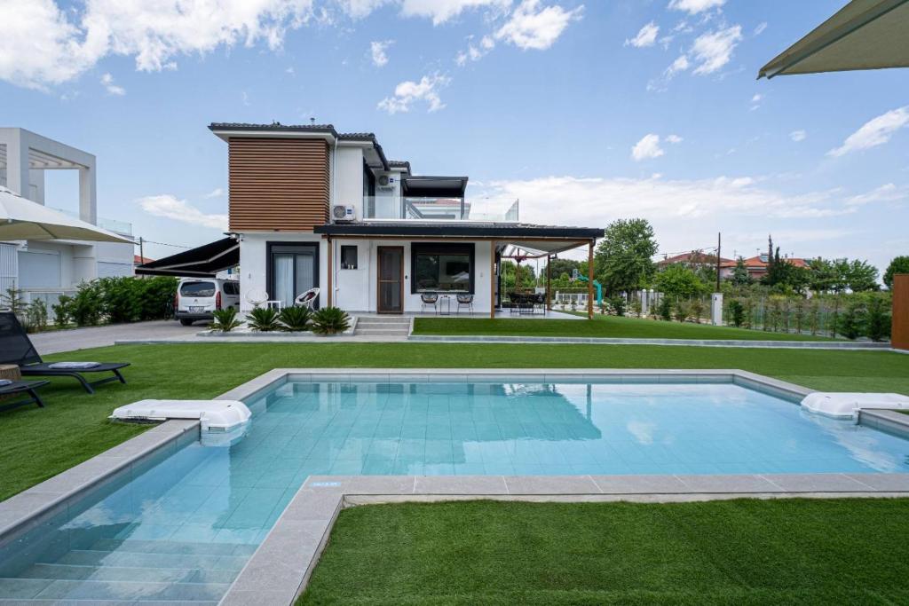 a swimming pool in the backyard of a house at Lobster in Leptokaria