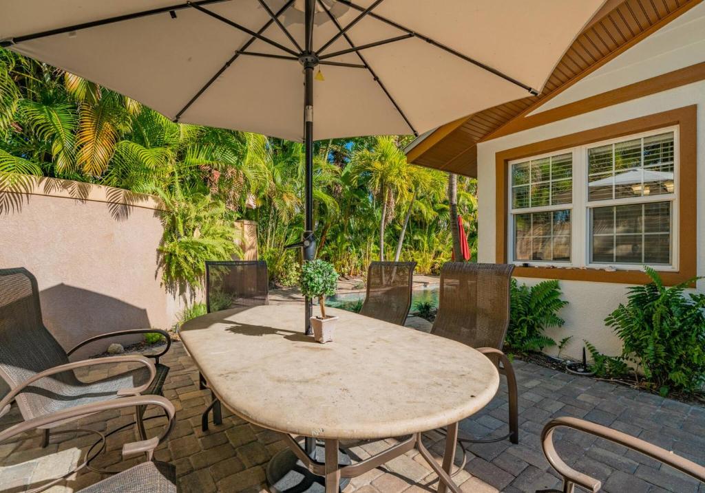 a table and chairs with an umbrella on a patio at Villa La Esperanza-Holmes Beach 201 in Anna Maria Island