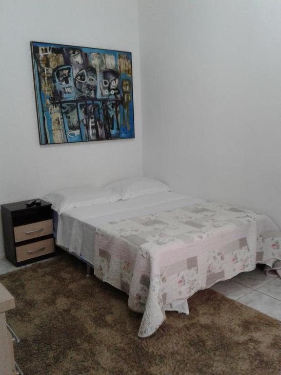 1 dormitorio con 1 cama y una foto en la pared en Apt no Menino Deus, en Porto Alegre