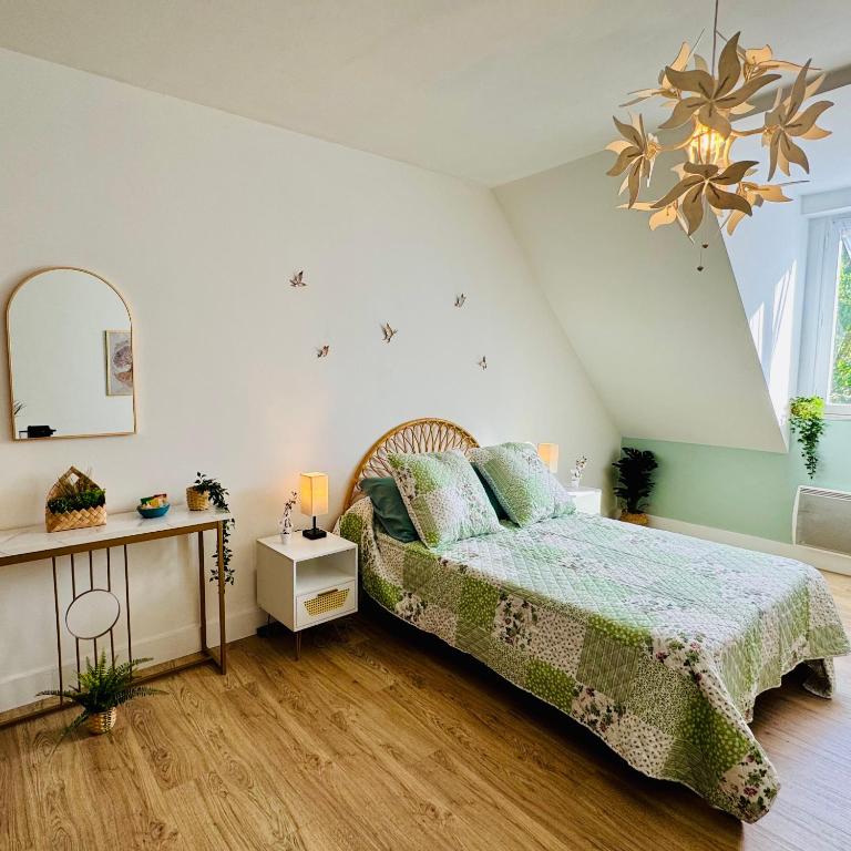 une chambre avec un lit et un lustre dans l'établissement Vaste studio au cœur de Solesmes, à Solesmes