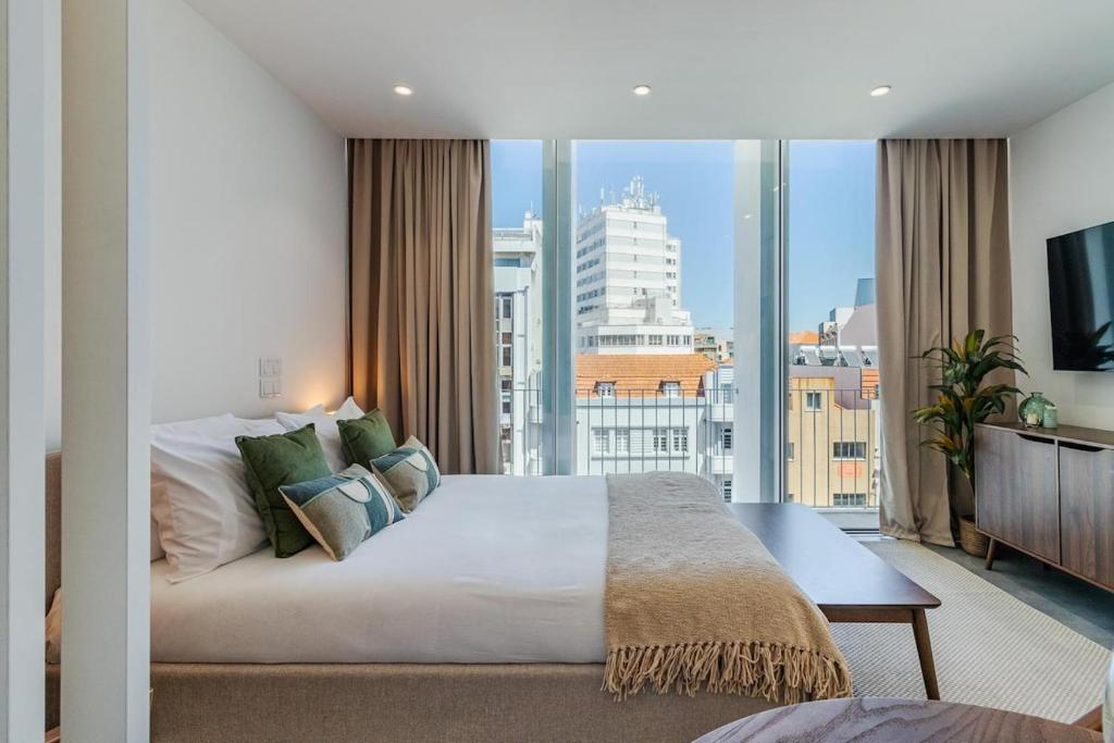 a bedroom with a large bed and a large window at Timeless Studio - Avenida in Aveiro