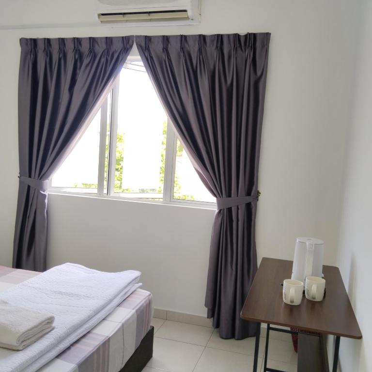 a bedroom with a window and a table with a bed at Happpy Impiana Guest House in Bentong