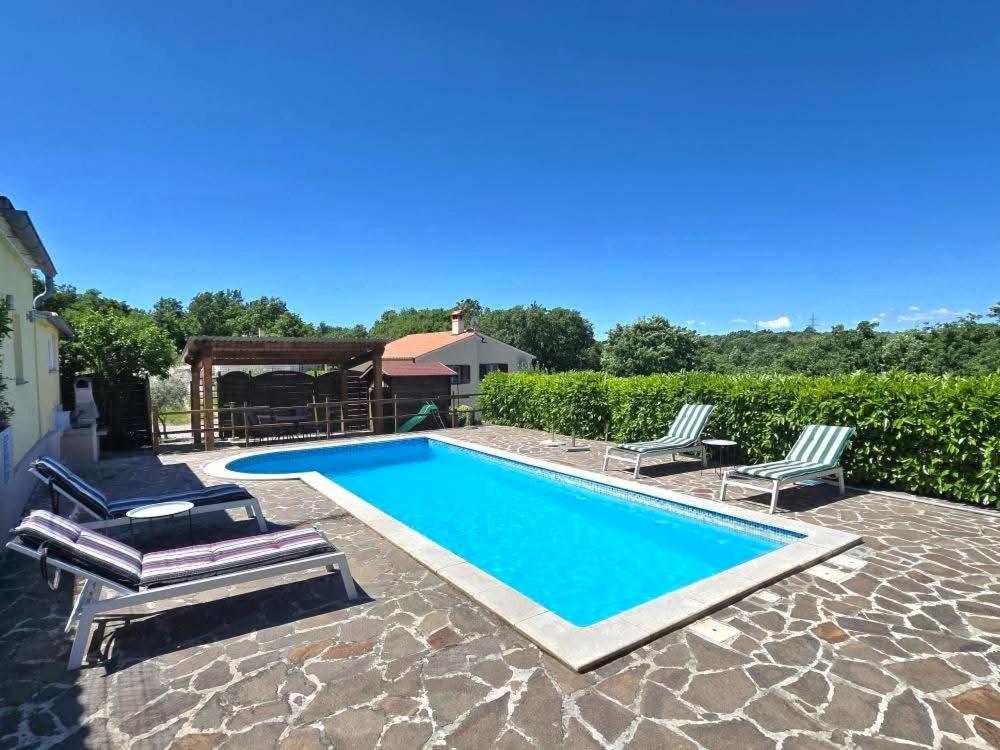 a swimming pool with two lounge chairs next to it at Villa Danica in Labin