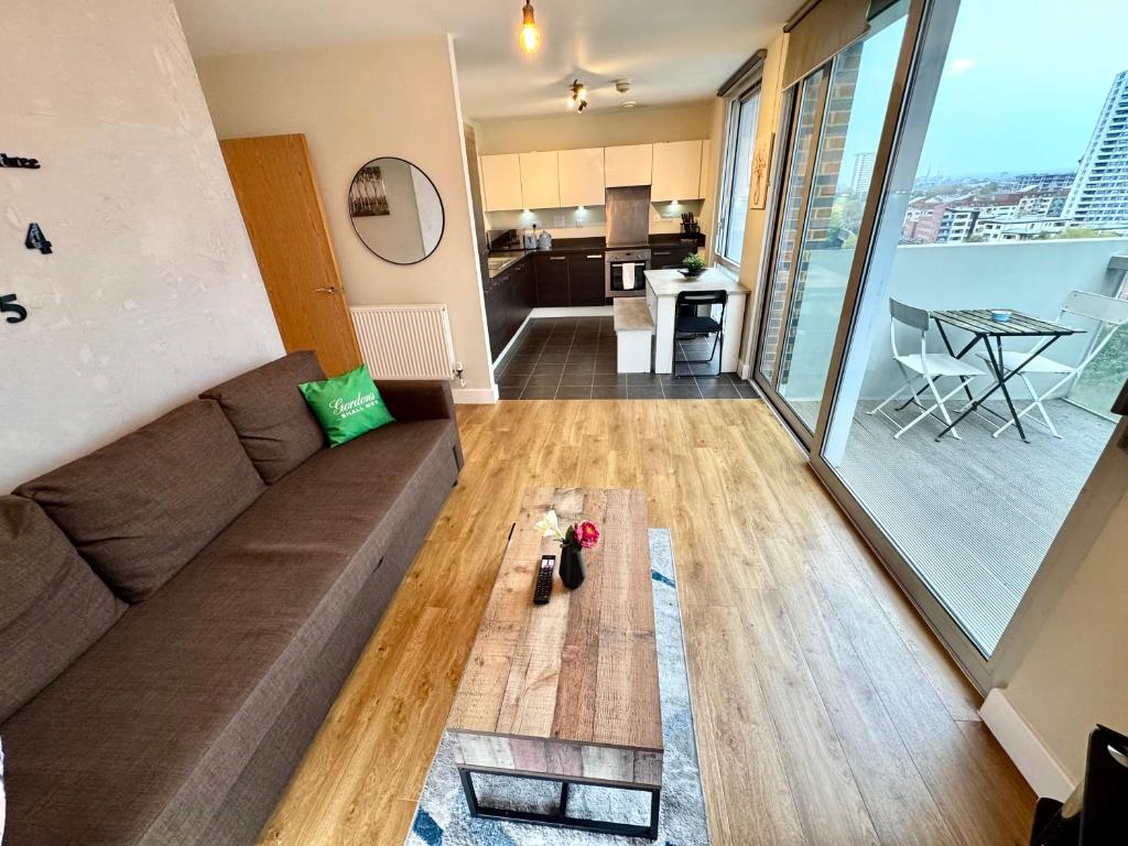 ロンドンにあるStylish 2Bedrooms 2Baths, Balcony Views, Stratford, ABBAのリビングルーム(ソファ付)が備わり、キッチンの景色を望めます。