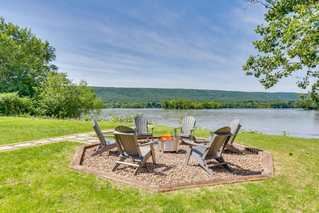 a group of chairs sitting around a table next to a lake at Steps to Susquehanna River Hot Tub Hideaway! in Dauphin