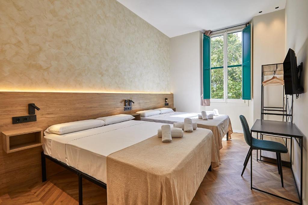a group of four beds in a room with a desk at Ella Hostel Boqueria in Barcelona