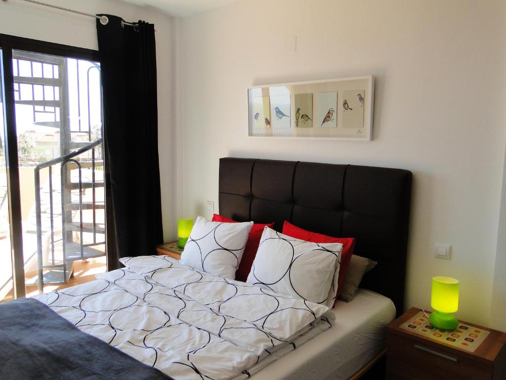 Una cama con almohadas rojas y blancas en un dormitorio en Villa Marina CC2, en Águilas
