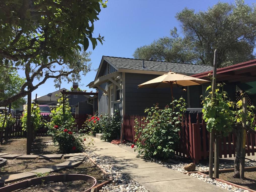 a house with an umbrella and a fence at Andrea's Hidden Cottage in Sonoma