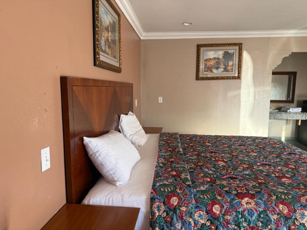 a hotel room with a bed with a floral bedspread at La PETITE ROUGE MOTEL in San Diego