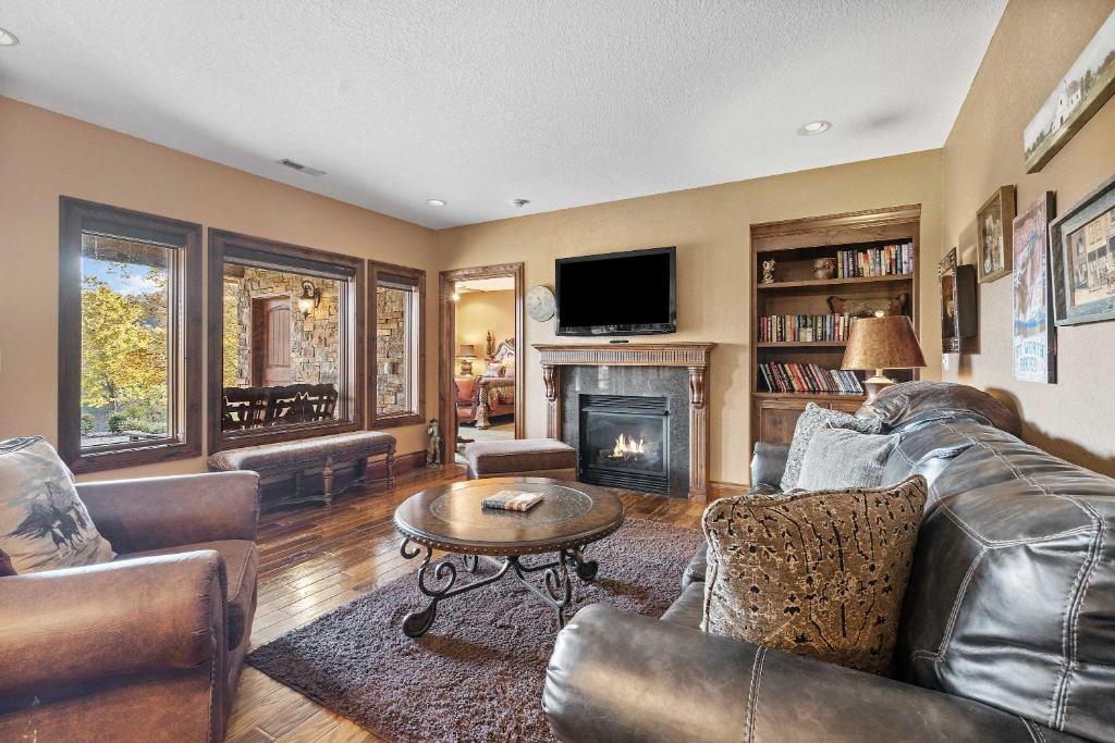 Una sala de estar con muebles de cuero y chimenea. en The Bunkhouse at Rock Canyon, en Branson
