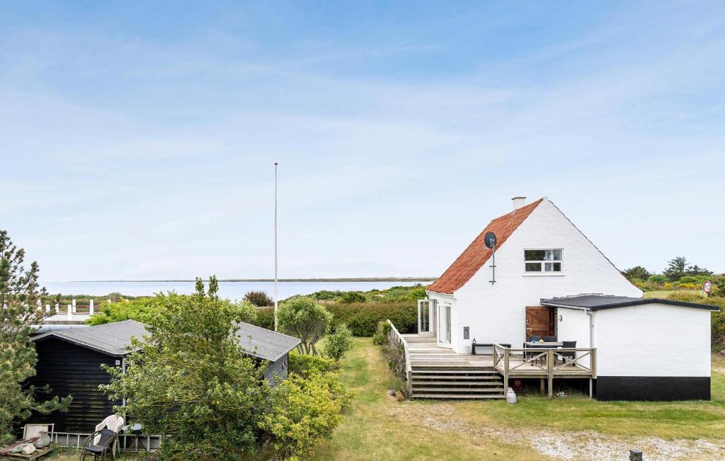 a white house with a porch and a deck at 5 Bedroom Awesome Home In Vestervig in Vestervig