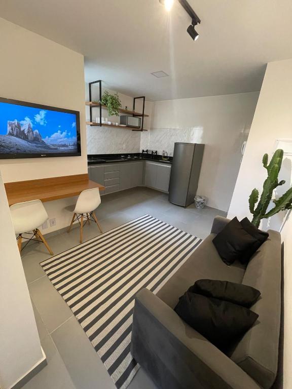 Lindo Apartamento - 600 metros da Praia de Itaparica في فيلا فيلها: غرفة معيشة مع أريكة وتلفزيون بشاشة مسطحة