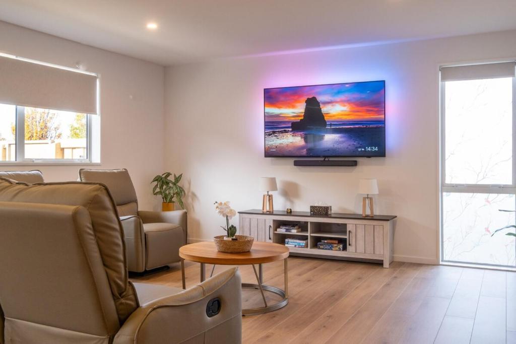 un soggiorno con un divano e una TV a parete di Brand New Games Room Family Home Sleeps 6 a Prebbleton