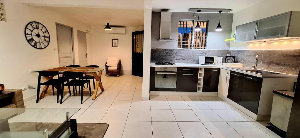 a kitchen with a table and a dining room at Meublé, moderne et tout équipé proche du centre in Fort-de-France