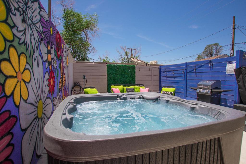 a jacuzzi tub in a backyard with a mural at Bohemian ChiC SpaCation-Private HotTub-Close to Downtown-No Pet Fee! in Albuquerque