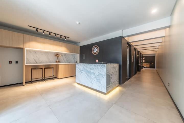 a large kitchen with a counter in a room at Ap novo, perto de Congonhas, com cama queen size in São Paulo