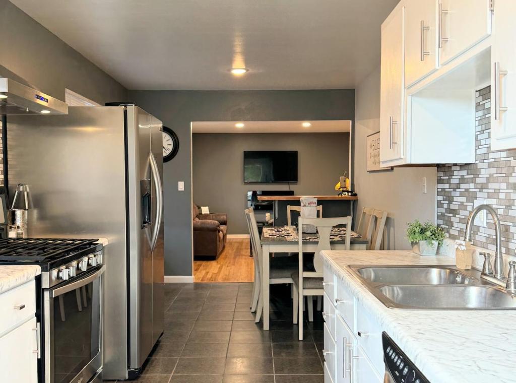 a kitchen with a stainless steel refrigerator and a table at Comfortable Family Getaway! in Cheyenne