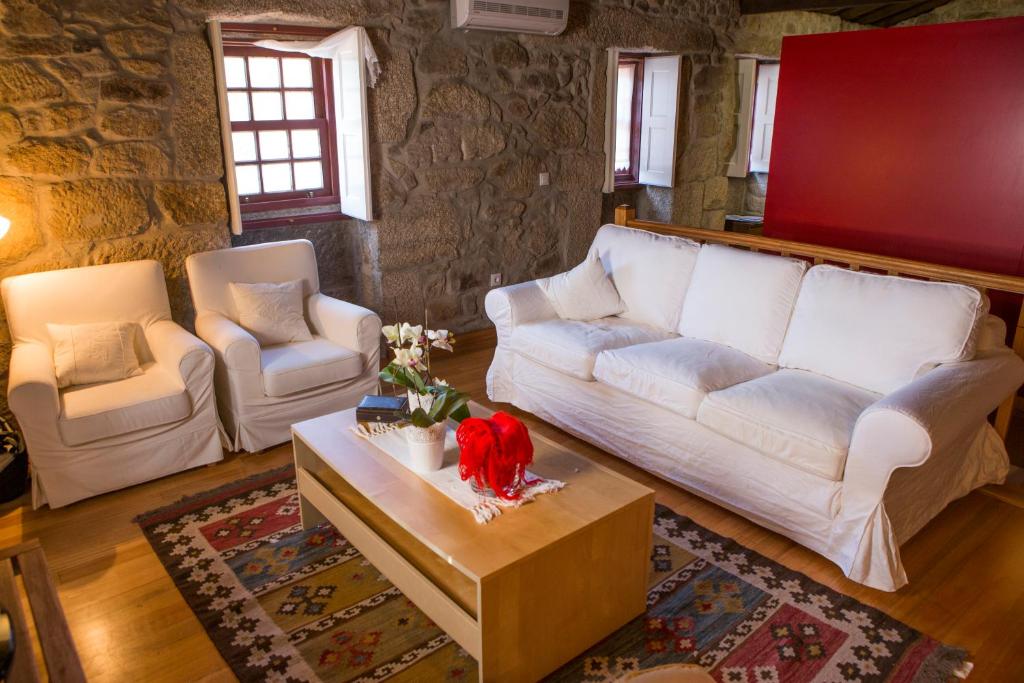 a living room with a white couch and a coffee table at Casa da Ferreirinha in Sistelo