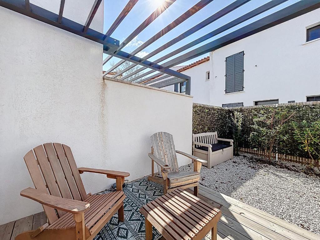 deux chaises assises sur le patio d'une maison dans l'établissement Maison Climatisée pour 4 Pers avec Animaux Admis - FR-1-475-224, à Saintes-Maries-de-la-Mer