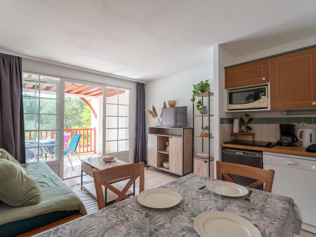 une cuisine et un salon avec une table et des chaises dans l'établissement Appartement avec balcon et piscine - Golf de Biscarrosse - 4 pers - FR-1-319-616, à Biscarrosse
