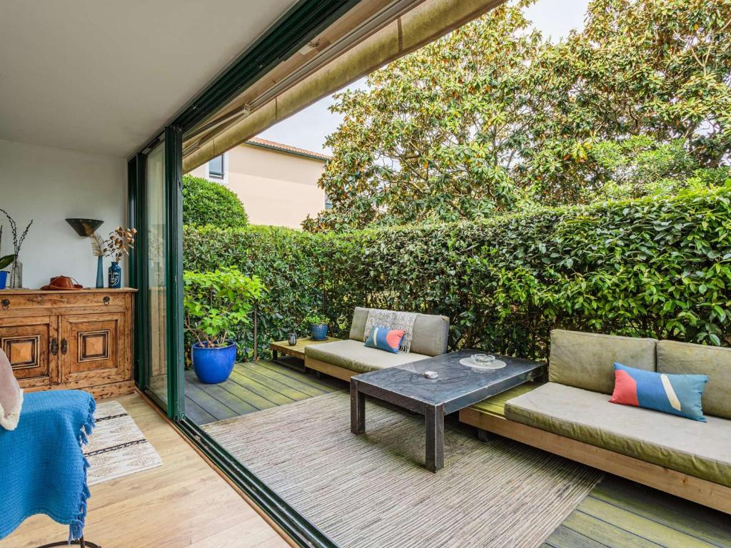 d'une terrasse avec deux canapés et une table. dans l'établissement Bel appartement avec terrasse à Anglet, proche des plages - FR-1-3-628, à Anglet