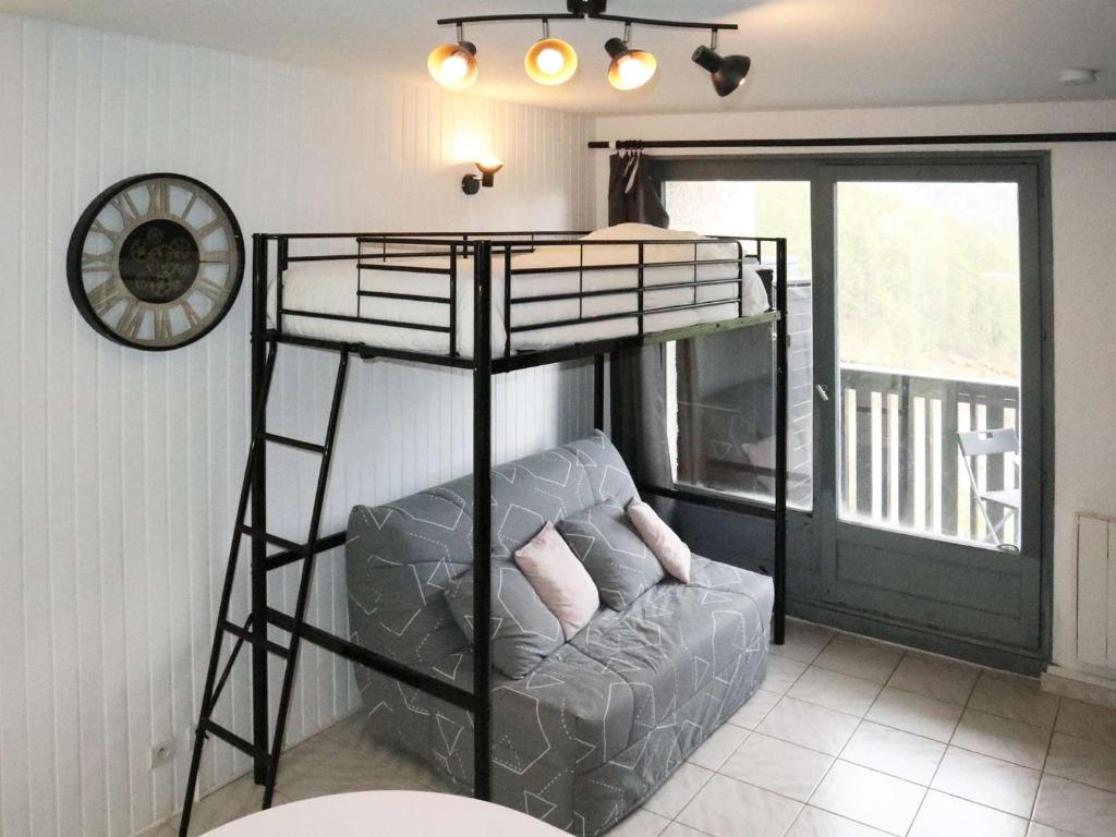 Ce lit superposé se trouve dans un dortoir doté d'un canapé et d'une chaise. dans l'établissement Charmant studio rénové 2 pers, centre des Orres - FR-1-322-670, aux Orres