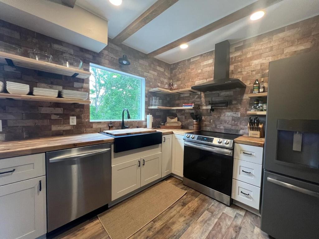 a kitchen with a sink and a stove at Charming Renovated Home Near Fayetteville, Rustic Retreat for Families in Raeford