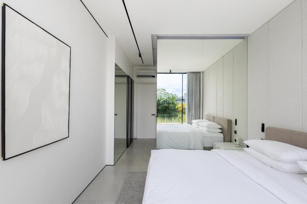 a bedroom with two beds and a large mirror at Archestet Villas Canggu in Canggu