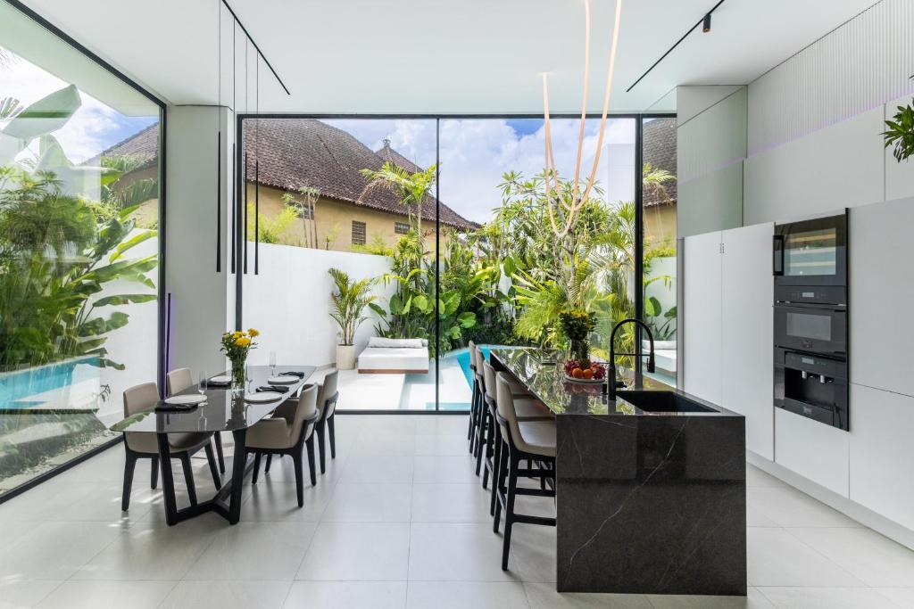 an open kitchen and dining room with large glass windows at Archestet Villas Canggu in Canggu
