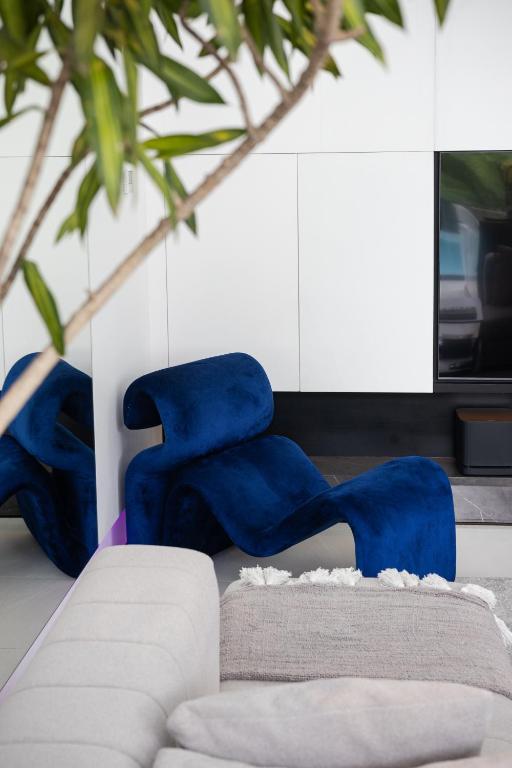 a living room with blue chairs and a couch at Archestet Villas Canggu in Canggu