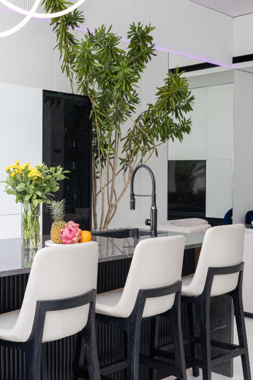 a kitchen with white chairs and plants at Archestet Villas Canggu in Canggu