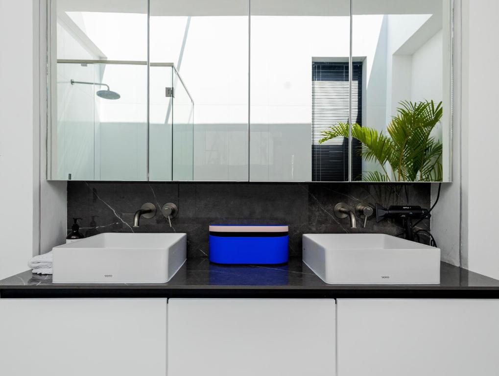 a bathroom with two sinks and a mirror at Archestet Villas Canggu in Canggu
