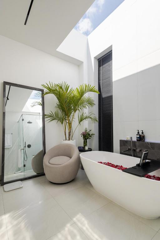 a bathroom with a tub and a toilet and a plant at Archestet Villas Canggu in Canggu